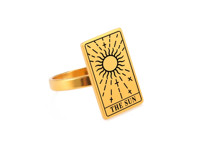 A gold tarot card ring engraved with the Wisdom card, stars above a serpent.