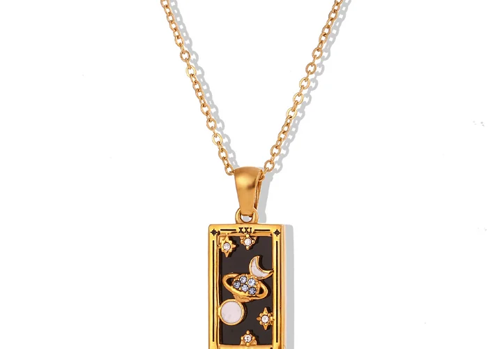 A gold rectangular tarot card pendant set with small clear stones, worn on a fine chain.